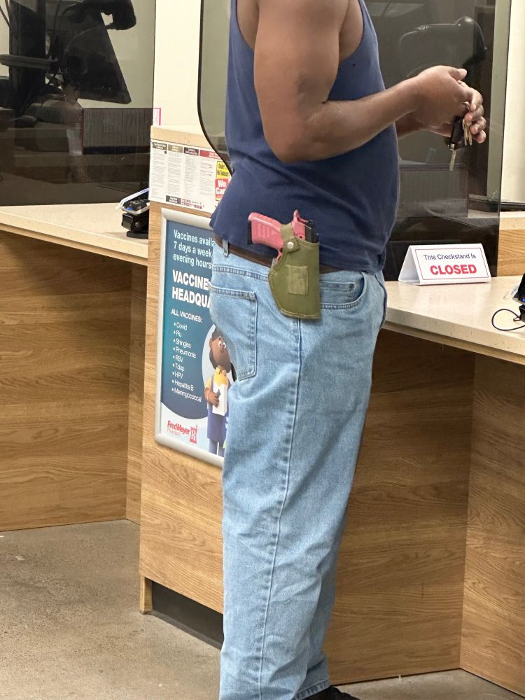 Waiting at the pharmacy desk with a pink handgun.
