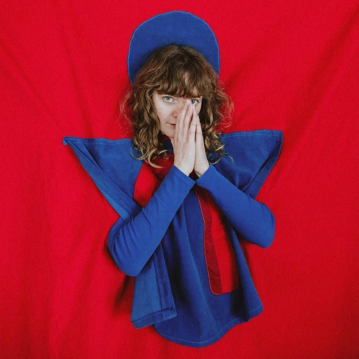 Me Lost Me - This Material Moment album cover. The artist in blue and red, against a red background. 
