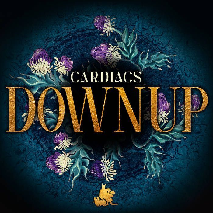 Cardiacs - Downup single cover. The band's name and single title in the centre of a circular blue image with a dark centre and thistles growing.