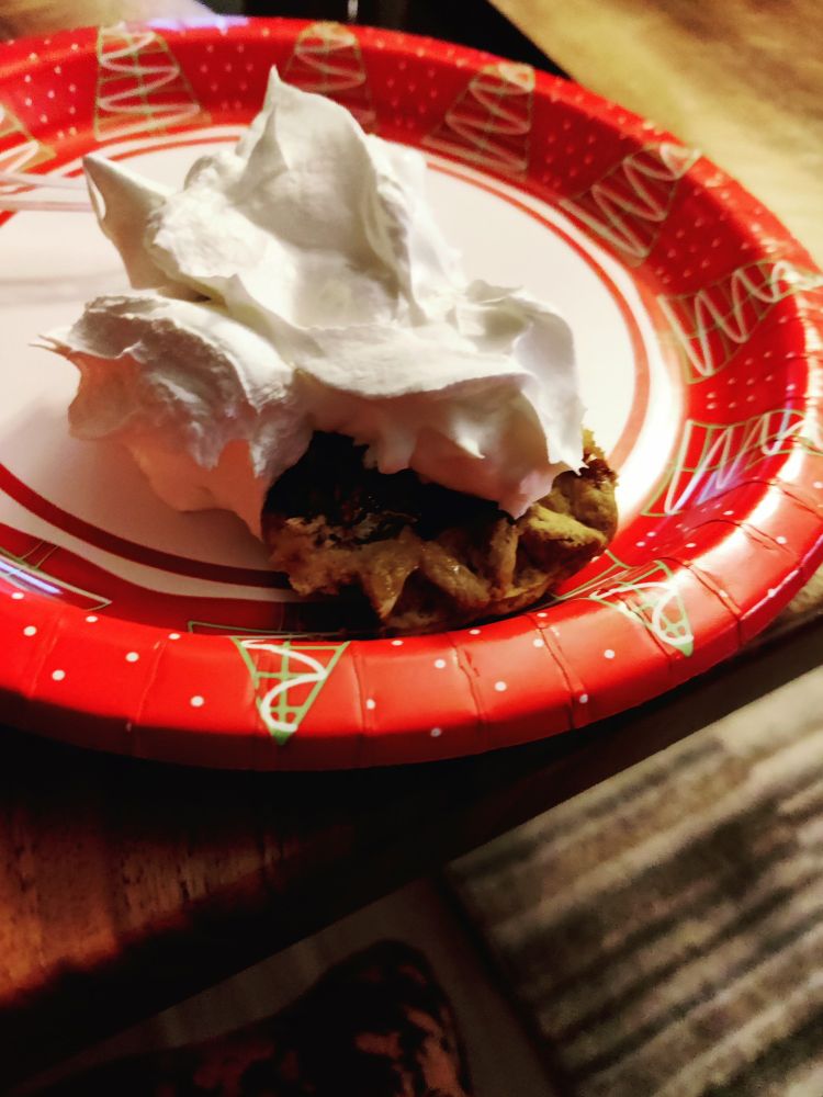 Slice of pecan pie under a mountain of whipped cream