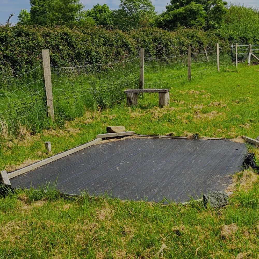 Picture of a bare fallow plot covered with a  black fabric to prevent the growth of plants 
