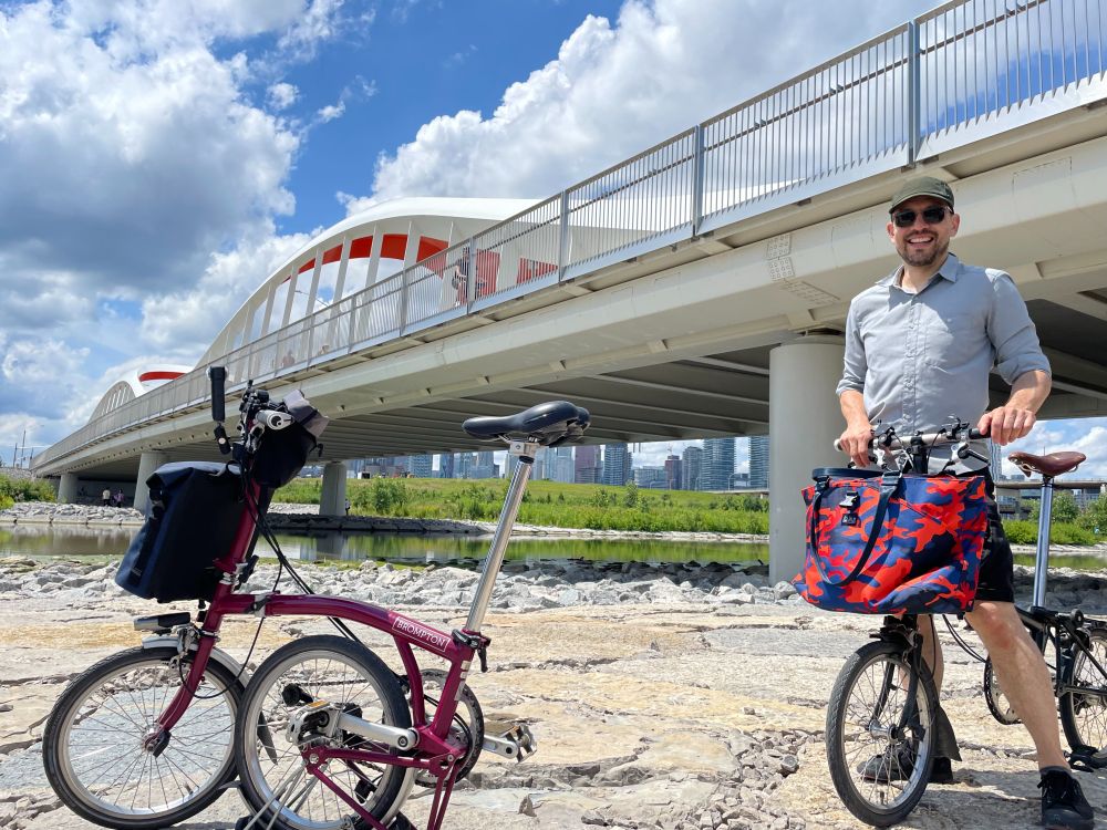 Two Brompton folding bikes under the Commissoners Street bridge in Biidaasige Park.