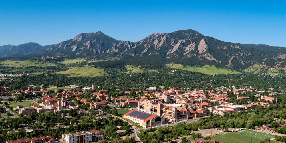 A photo of Boulder, Colorado, shot from above the university campus and looking toward the Flatirons.