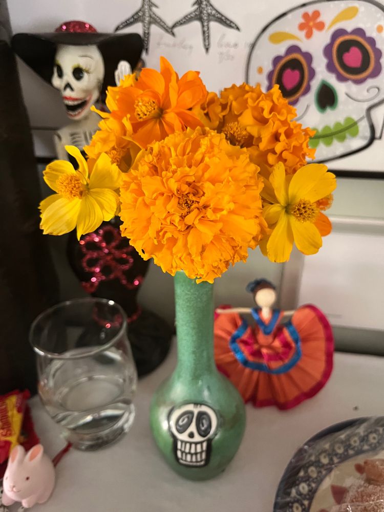 Marigolds in a skellramics vase on a dia de Los muertos ofrenda 