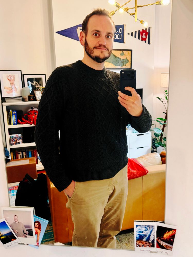 A mirror selfie wearing a dark grey cable sweater. 
