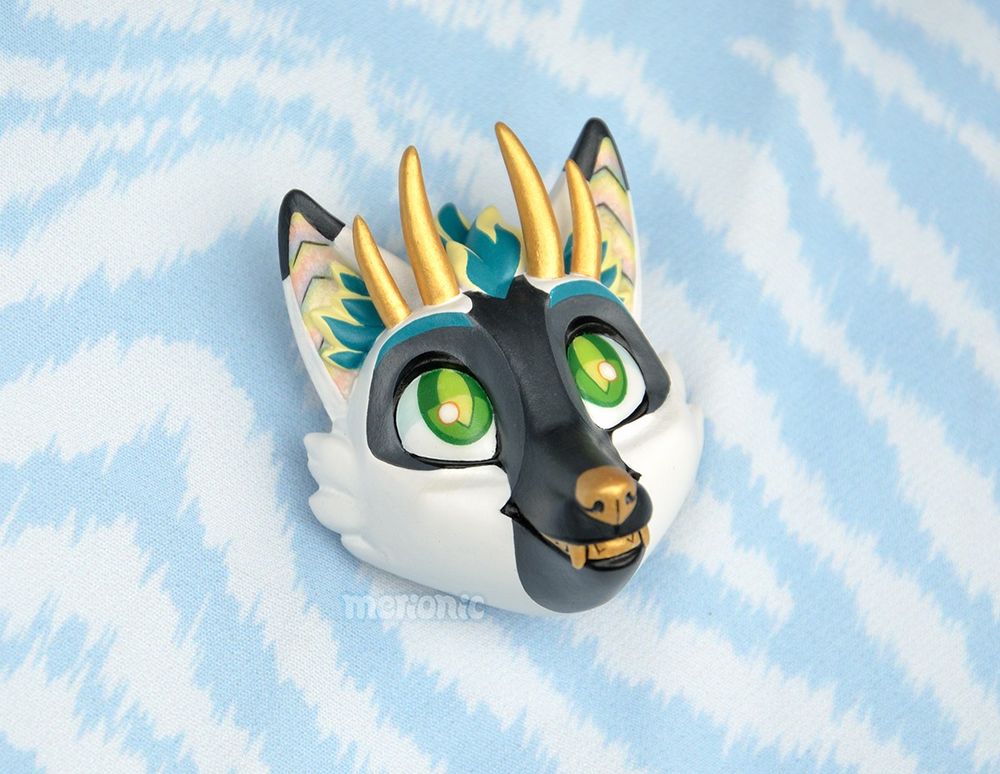 Photo of a handmade fridge magnet. It's a head of a dragon character.