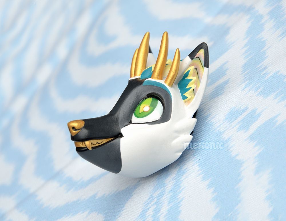 Photo of a handmade fridge magnet. It's a head of a dragon character.