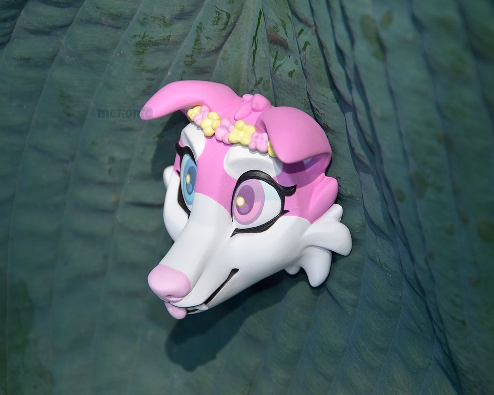 Photo of a handmade fridge magnet, it's a pink dog character.