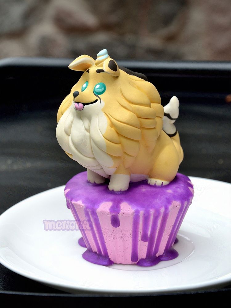 Photo of a cupcake figurine. The frosting is shaped like a dog character. 