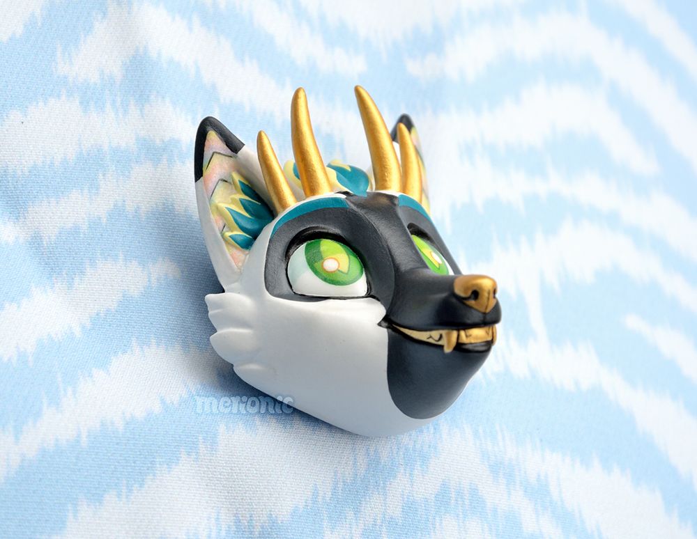 Photo of a handmade fridge magnet. It's a head of a dragon character.