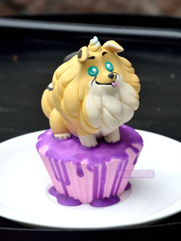 Photo of a cupcake figurine. The frosting is shaped like a dog character.