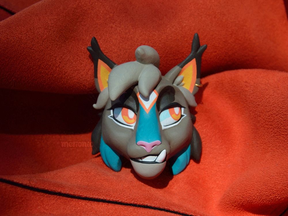 A handmade fridge magnet. It's a head of a lynx character.