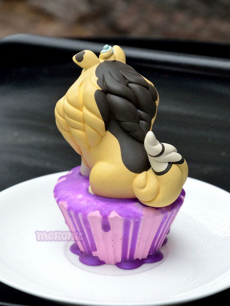 Photo of a cupcake figurine. The frosting is shaped like a dog character. 