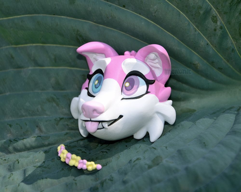 Photo of a handmade fridge magnet, it's a pink dog character.