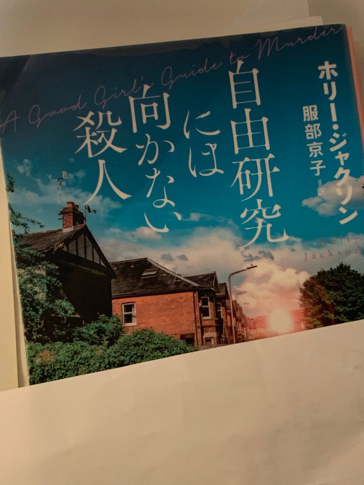 ホリー・ジャクソン作、服部京子訳『自由研究には向かない殺人』表紙。雲の浮かぶ濃い青空を背景にイギリスのであろう住宅地のリアルなイラスト。マンション広告のCGみたいなイラスト。