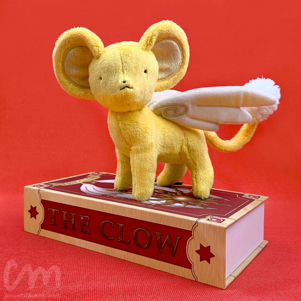 Life size Kero plush standing on The Clow Book