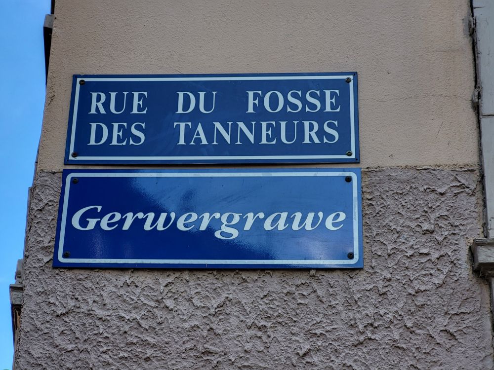 Street sign saying in French "rue du fossé des tanneurs" and in Alsatian "Gerwergrawe"