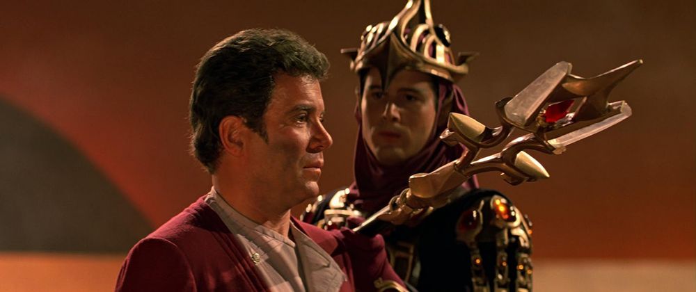 Captain kirk facing an unamused Vulcan guard wielding an overdecorated trident