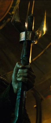 A hand holding on to a trident like weapon