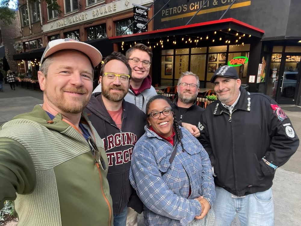 Six people are standing staring at the camera and smiling. 