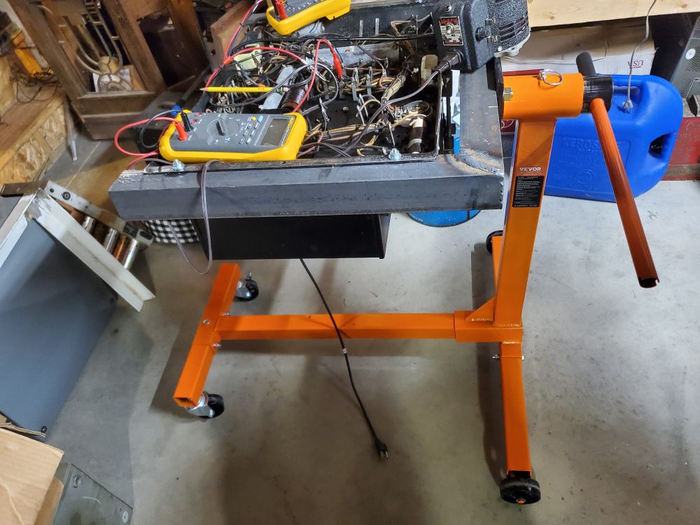 The power supply mounted onto an automotive engine stand to support its weight making it easier to work on