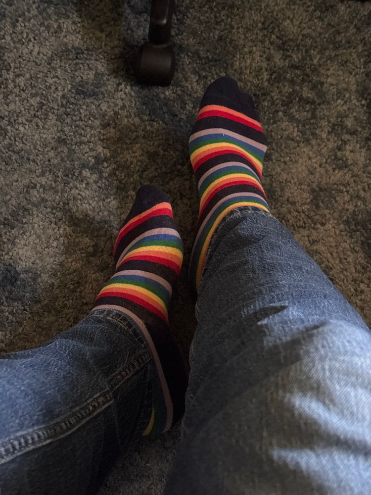 A picture of my feet in rainbow striped socks 