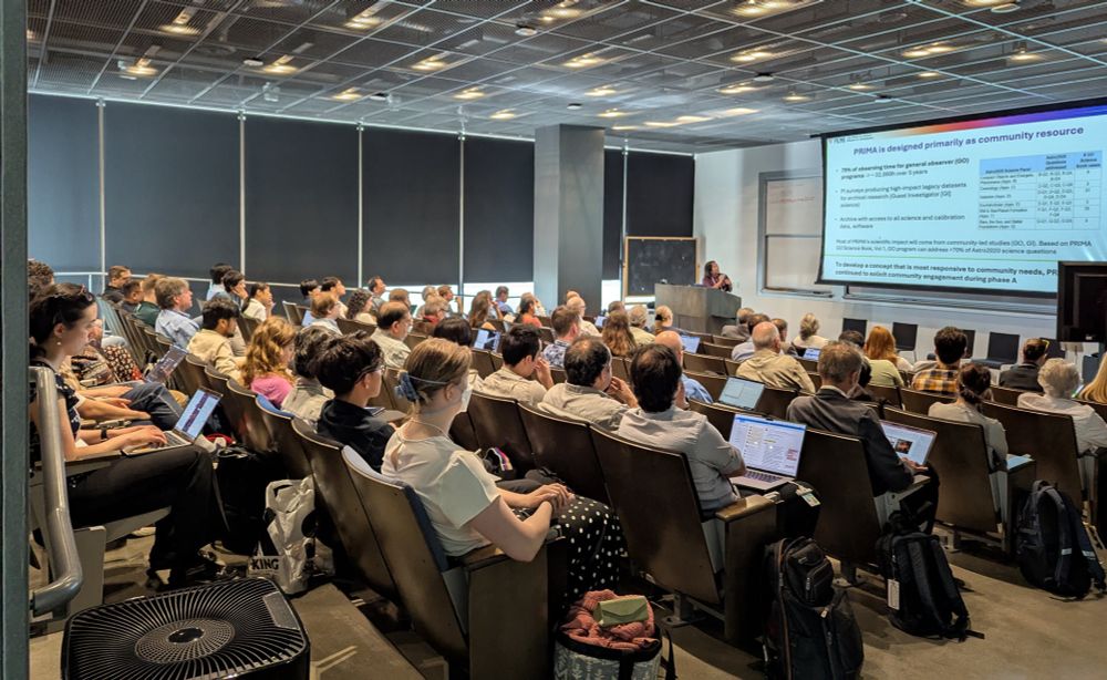 This is a photo of the in-person attendees of the PRIMA working meeting, held in the Hameetman Auditorium in the Cahill Center for Astronomy and Astrophysics on the Caltech campus, May 19-21, 2025. The photo, taken from the rear-right area of the auditorium, shows the audience watching a presentation by Dr. Tiffany Kataria, who is at the front of the auditorium presenting a slide on the proposed PRIMA space telescope. Image credit: Marcy Harbut, Caltech/IPAC