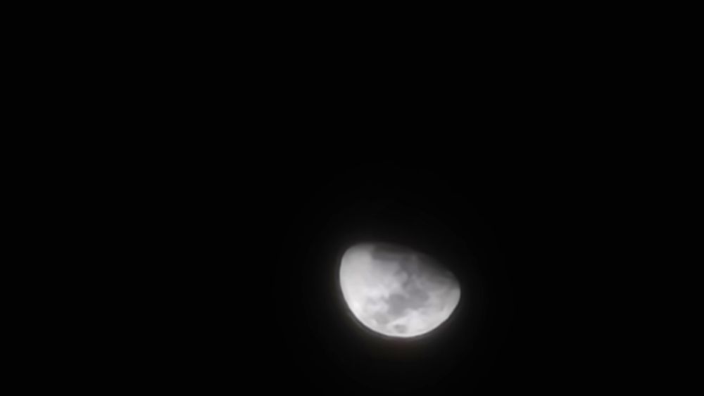 Waxing moon in a dark sky.