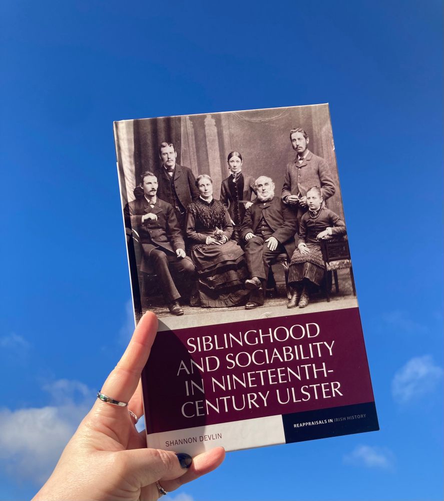 A copy of Siblinghood and Sociability in Nineteenth-Century Ulster by Shannon Devlin against a blue sky. 