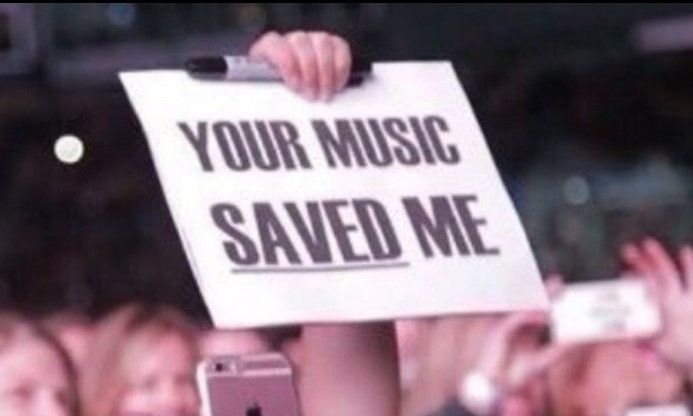 A sign saying 'YOUR MUSIC SAVED ME'