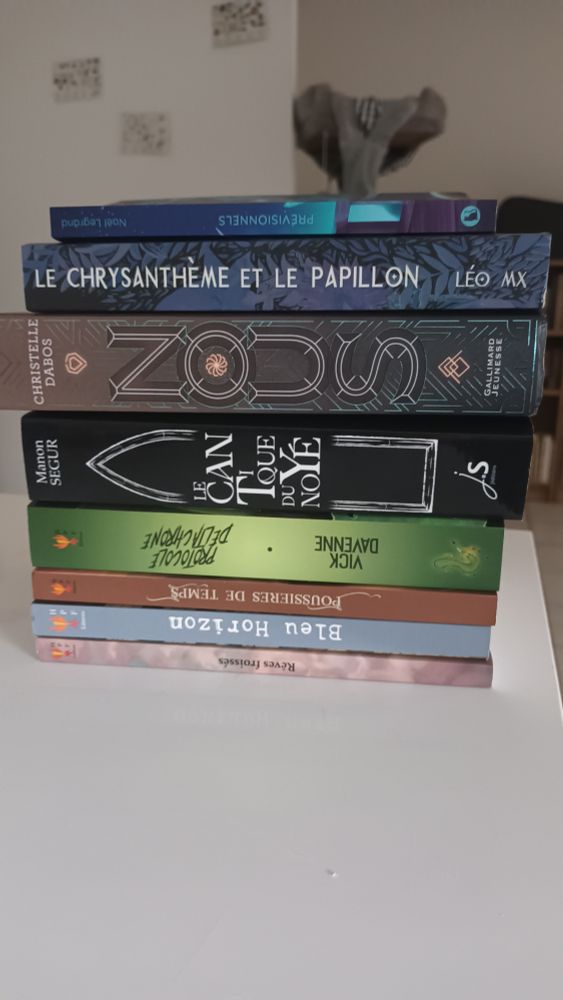 Une pule de huit livres. De bas en haut : Rêves froissés, Bleu Horizon, Poussière de Temps, Protocole Deltachrone, Le Cantique du Noyé, Nous, Le Chrysanthème et le Papillon, Prévisionnels
