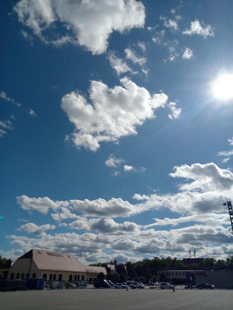 Blauer Himmel mit Wolken in der Ferne ein Gebäude und Autos 