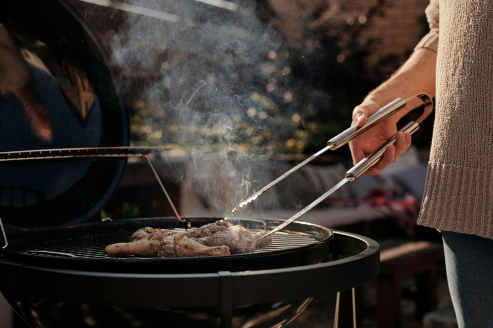 close up of a person tending a BBQ