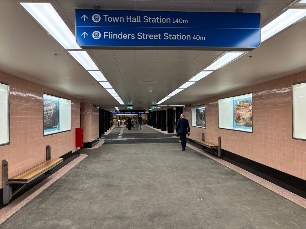 View of the Campbell arcade with sign showing Town Hall Station 140m Flinders Street station 40m