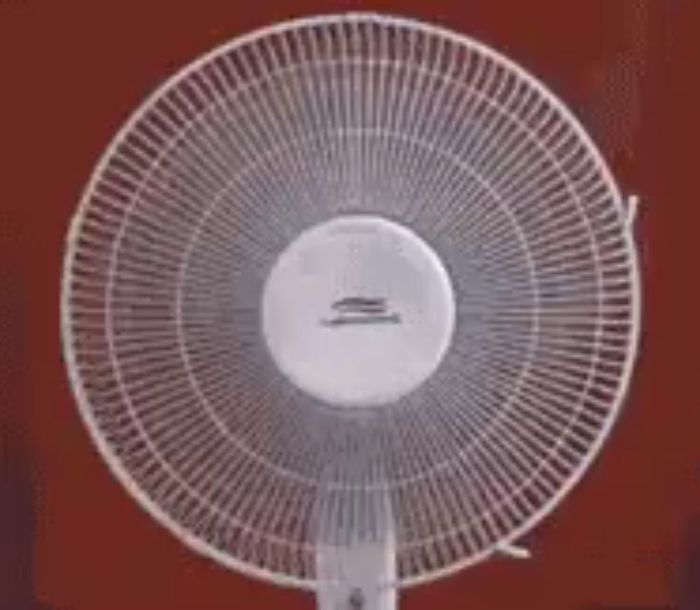 a white fan is sitting on a red background .