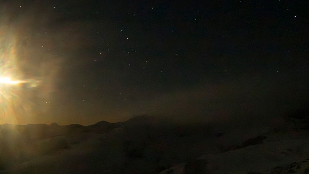 Photographie de paysage d'hiver, de nuit, avec ciel étoilé et pleine lune irradiant dans son halo. Le vent soulève la neige poudreuse. Massif Central, France.

Winter landscape photography, at night, with starry sky and full moon starring in its halo. Snow blown by the wind. Massif Central, France.