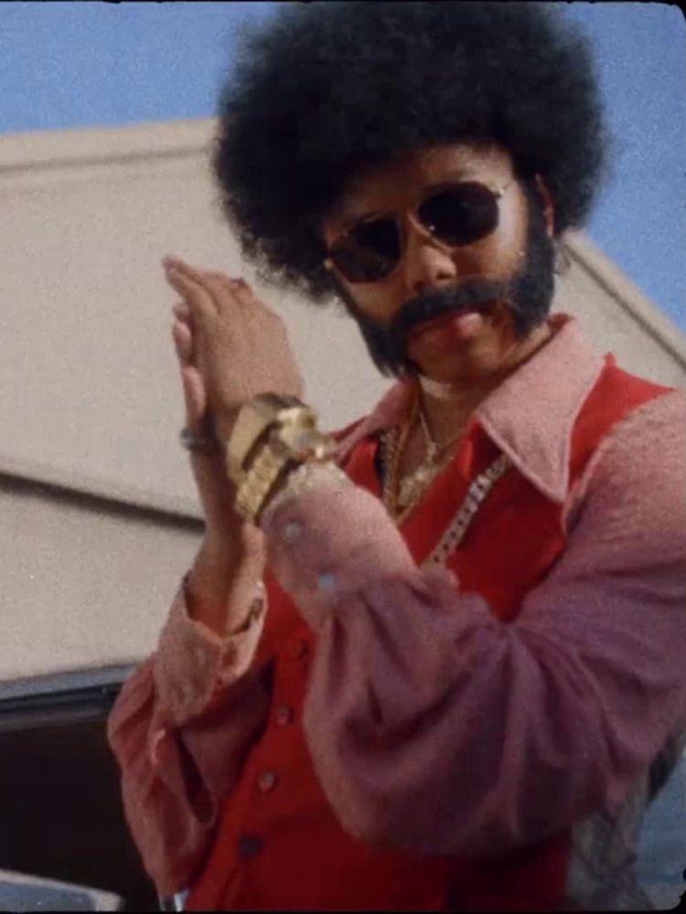 a man with an afro and a beard wearing sunglasses