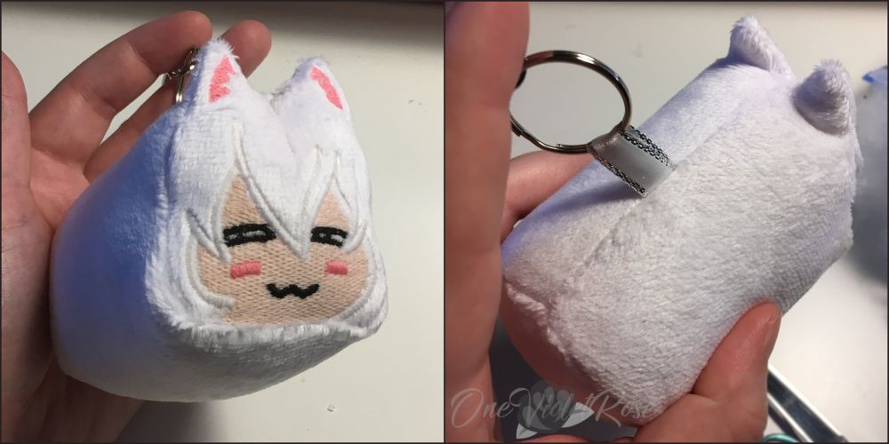 Fist-size plushie of a white loaf of bread with an anime catgirl face