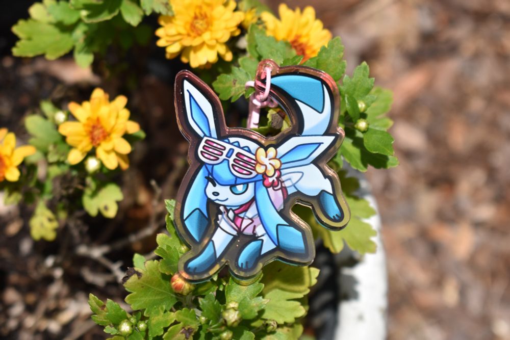 an acrylic keychain featuring glaceon's beach style from pokemon unite
