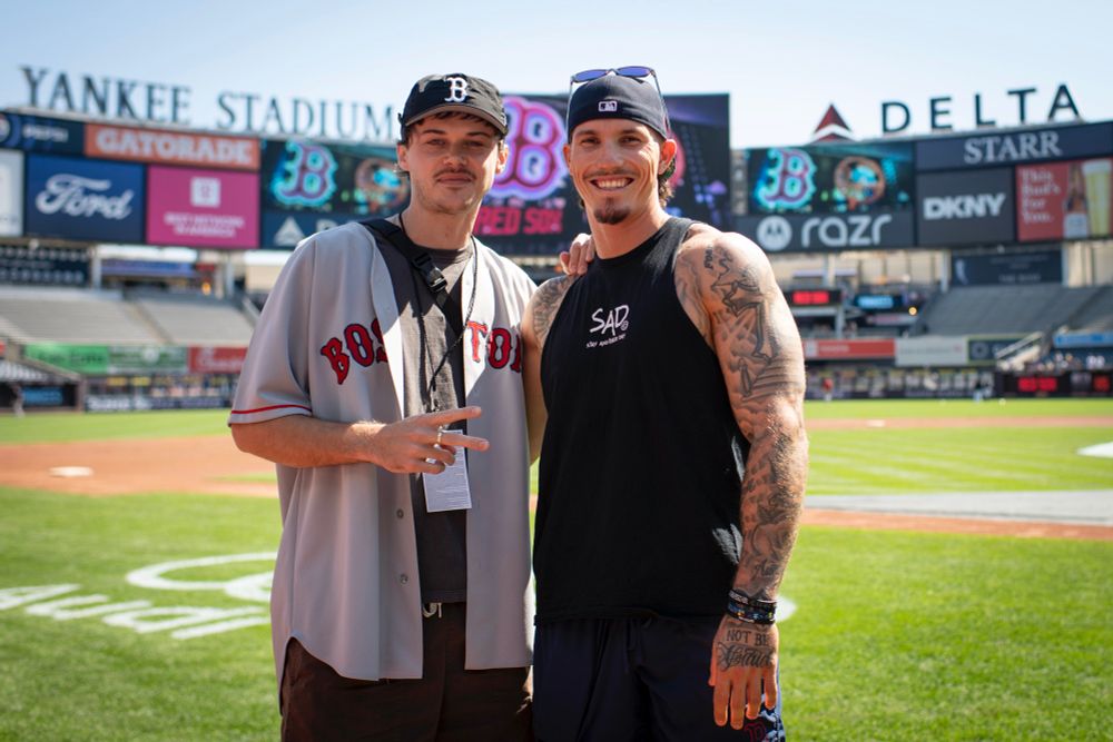 Actor Christopher Briney of The Summer I Turned Pretty poses with Jarren Duran on the field at Yankee Stadium while wearing a Red Sox jersey.