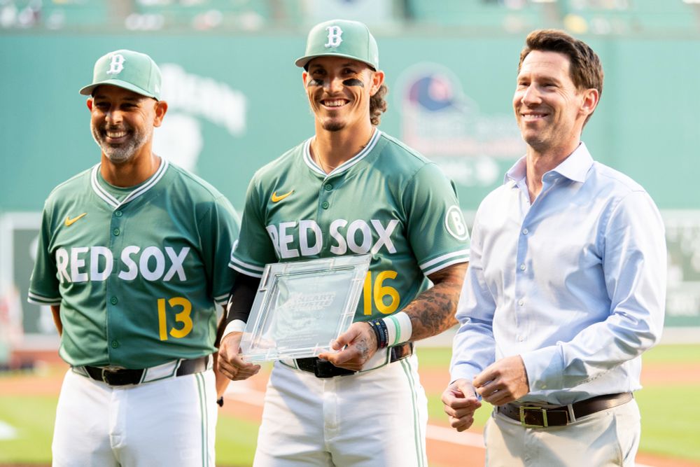 Alex Cora, Jarren Duran and Craig Breslow stand on the field at Fenway Park as Jarren receives the Red Sox 2025 Heart & Hustle Award.