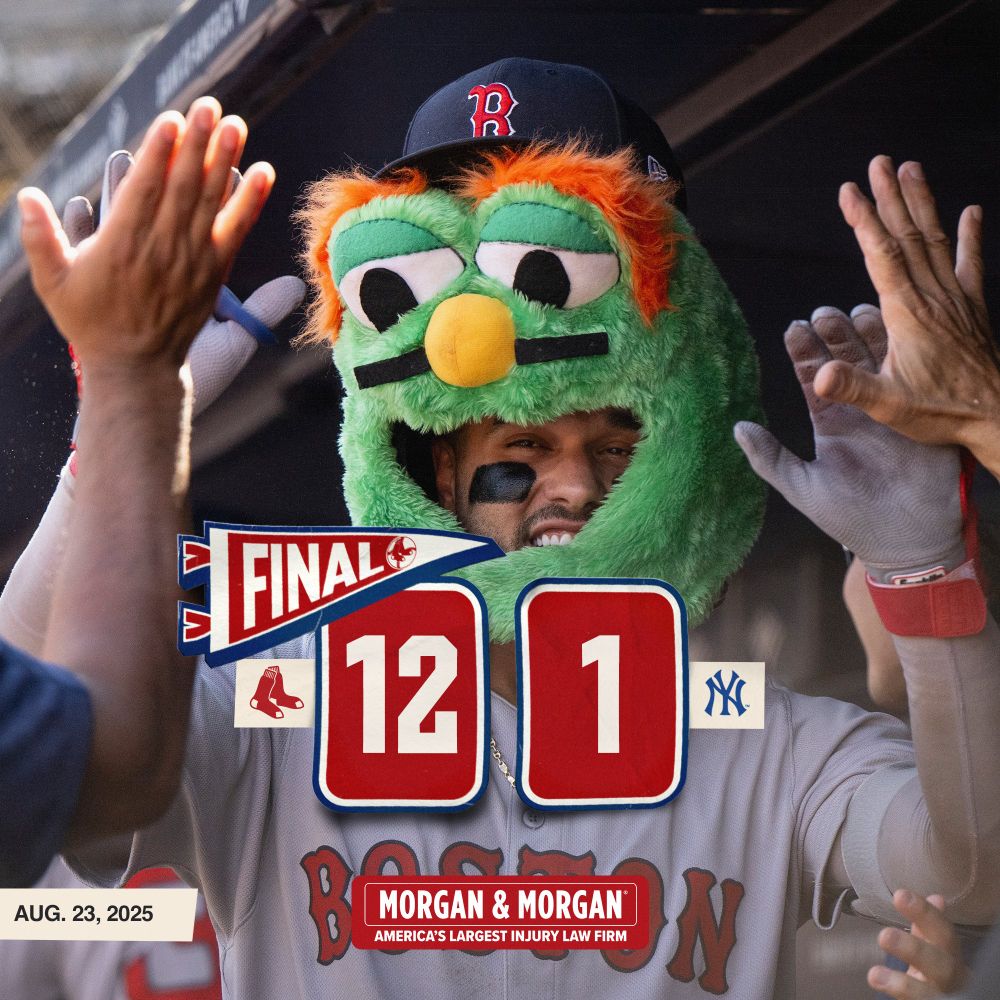 TEXT: FINAL - Red Sox 12, Yankees 1. Aug. 23, 2025. IMAGE: Carlos Narváez celebrates in the dugout with the Wally head on after hitting a home run at Yankee Stadium.