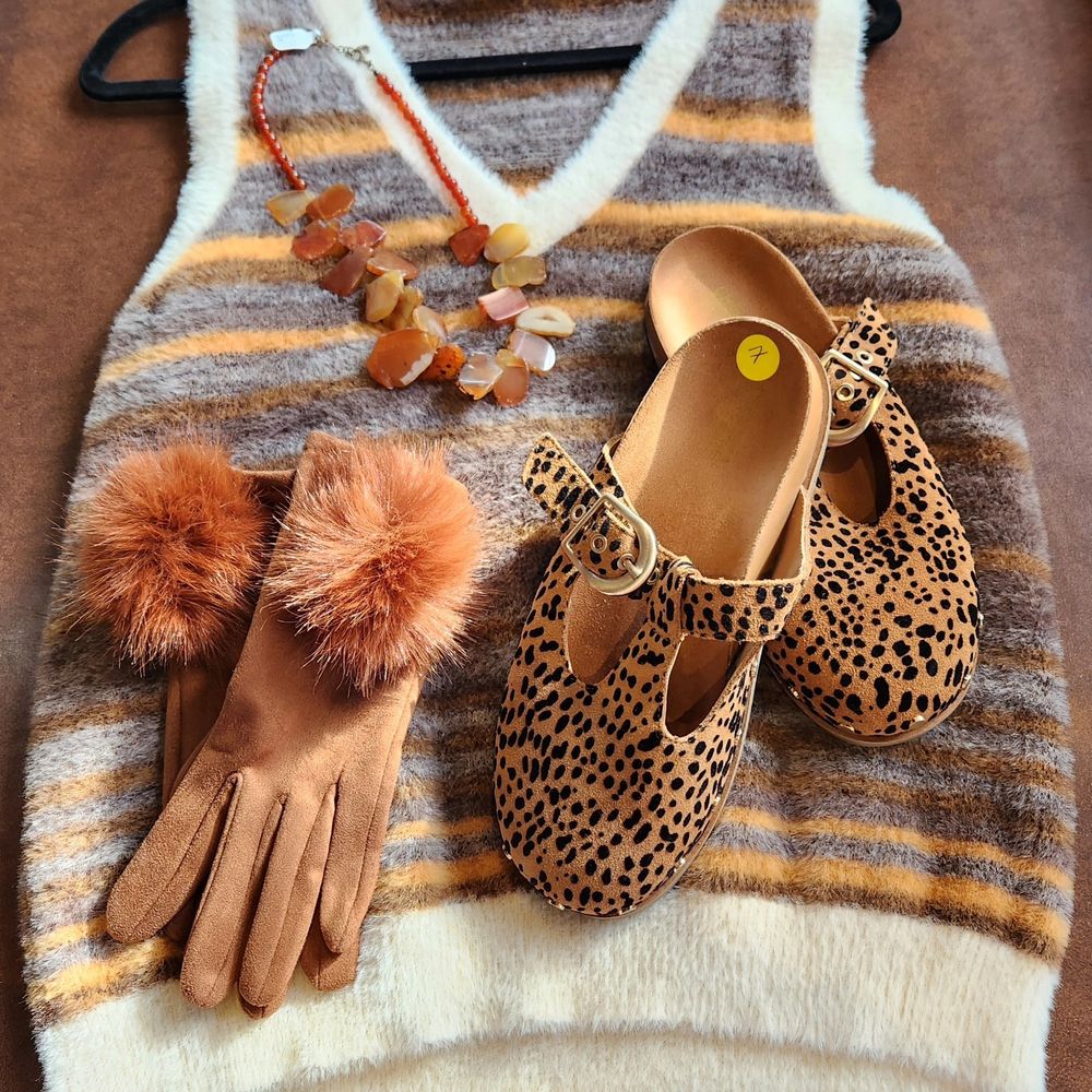 A selection of cozy accessories and apparel—all in warm earthtones—including gloves, a chunky necklace, fleecy sweater vest, and leopard print Mart Jane-style shoes. All available from Northside Cellar in downtown Akron, Ohio