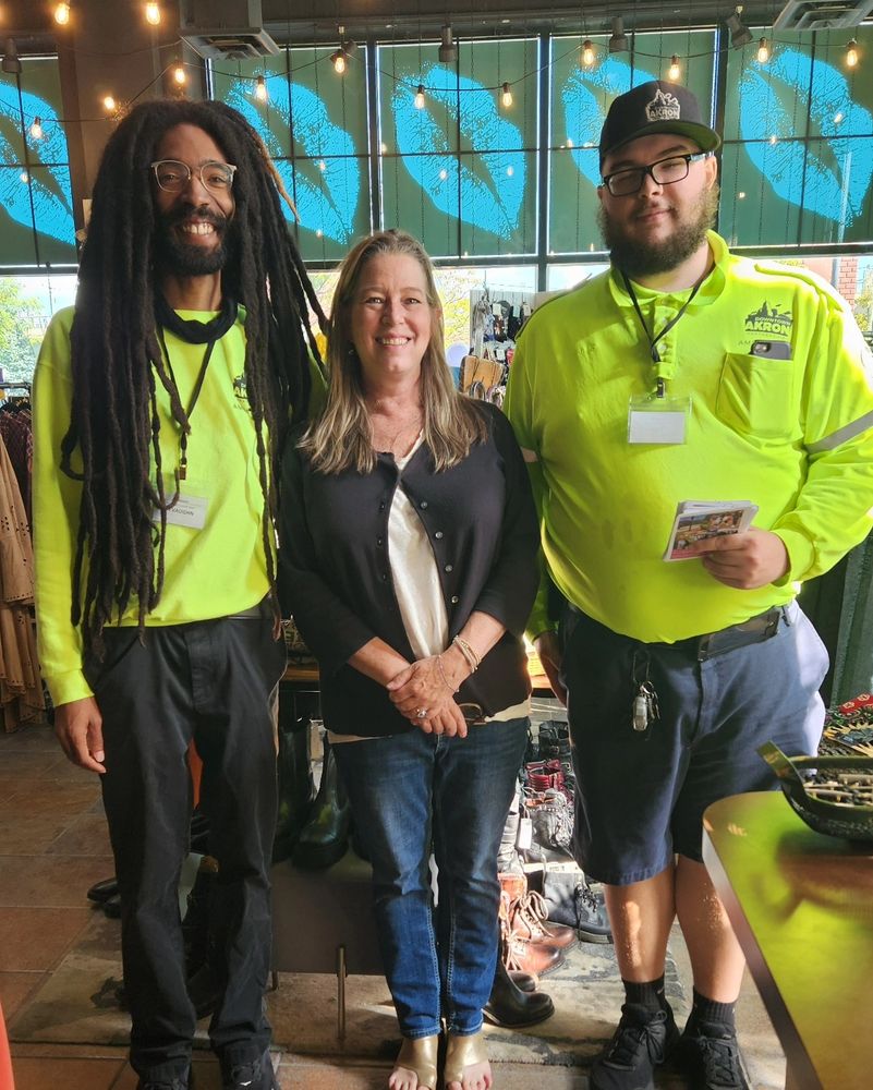 Photograph of downtown Akron ambassadors Devaughn and Nick with a staff member in the Northside Cellar boutique during a business check-in. 