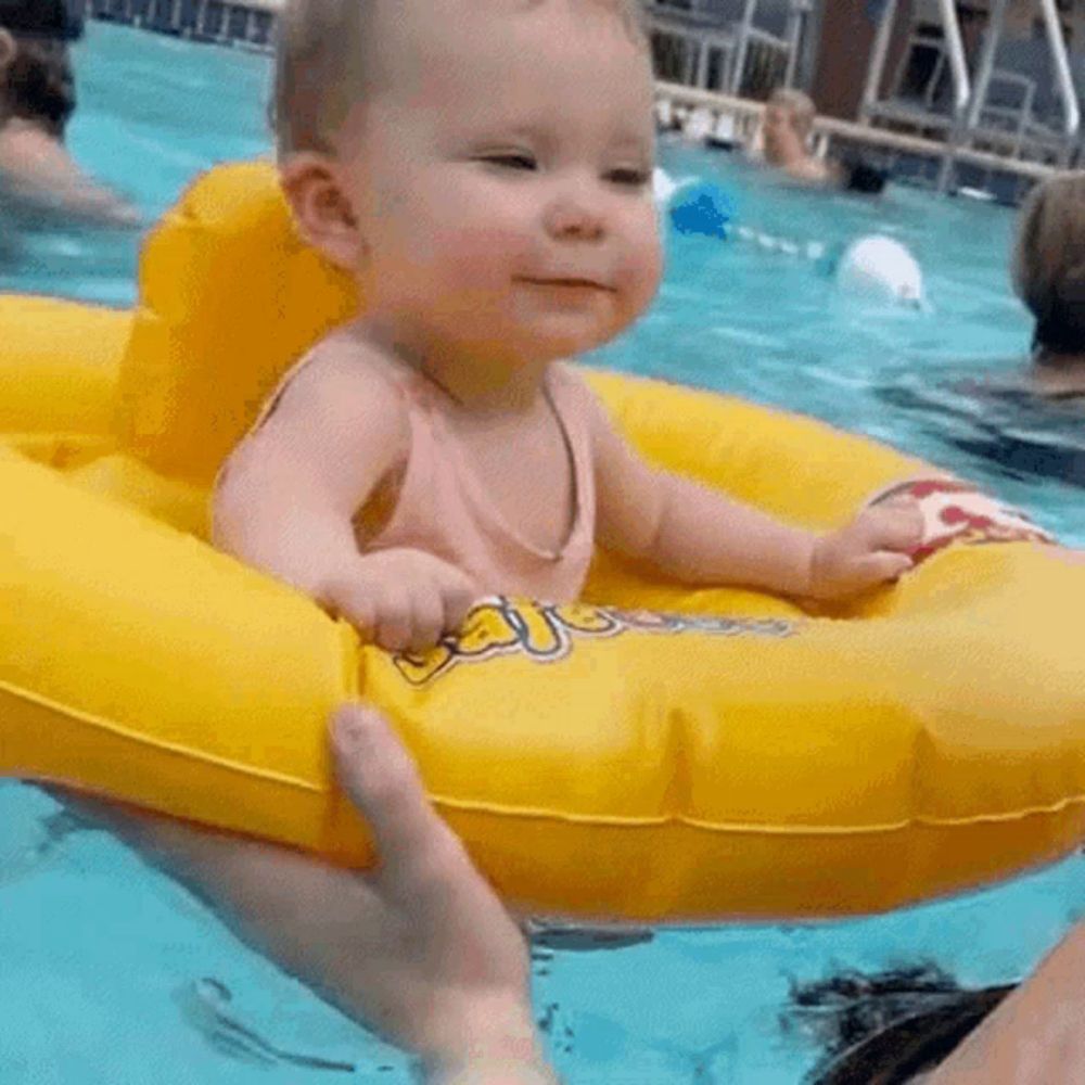 a baby is sitting on an inflatable raft in a pool .