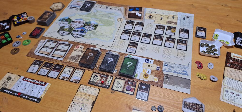 Robinson Crusoe Setup mit Spielbrett, Spielertableaus, vielen Markern und Spielsteinen und Karten