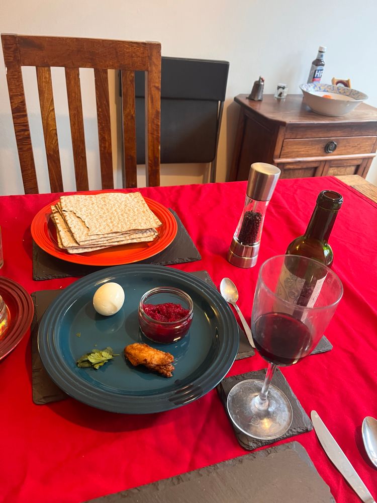 A Passover setting with a plate with items for the Seder, wine and matzah 