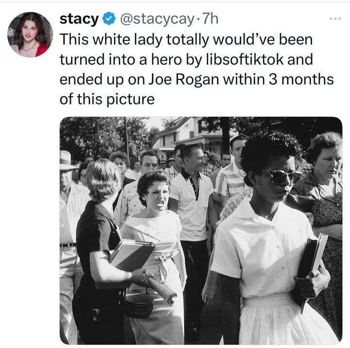 A tweet from user Stacy (@stacycay) features a historical black-and-white photograph of Elizabeth Eckford, one of the Little Rock Nine, walking alone while being harassed by a white mob during the desegregation of Little Rock Central High School in 1957. The image prominently shows a white woman angrily yelling behind Eckford.