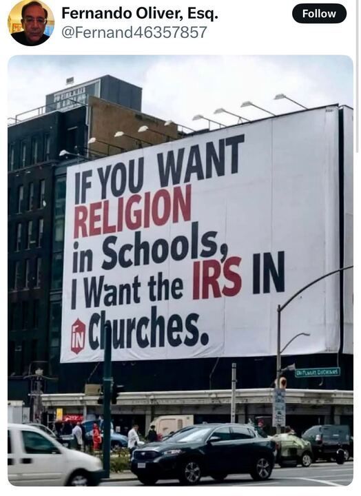 A tweet from Fernando Oliver, Esq. (@Fernand46357857) featuring a large billboard on the side of a building. The billboard reads: "IF YOU WANT RELIGION in Schools, I Want the IRS IN Churches." The words "RELIGION" and "IRS" are highlighted in red, while the rest of the text is black. The image captures a busy urban street with cars and pedestrians passing by.
