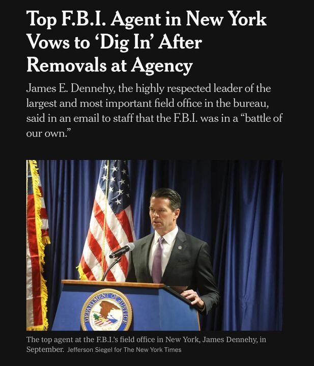 A New York Times article headline reads: "Top F.B.I. Agent in New York Vows to ‘Dig In’ After Removals at Agency". The subheading states: "James E. Dennehy, the highly respected leader of the largest and most important field office in the bureau, said in an email to staff that the F.B.I. was in a 'battle of our own.'". Below the text, there is a photo of a man standing at a podium with the seal of the Department of Justice. An American flag and another flag are in the background. The caption under the photo reads: "The top agent at the F.B.I.'s field office in New York, James Dennehy, in September. Jefferson Siegel for The New York Times."